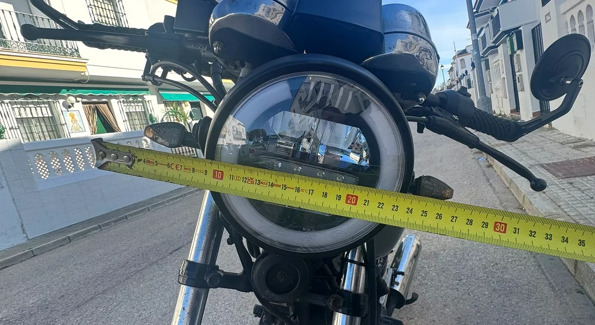 Midiendo con una cinta la separación entre los intermitentes delanteros de una moto