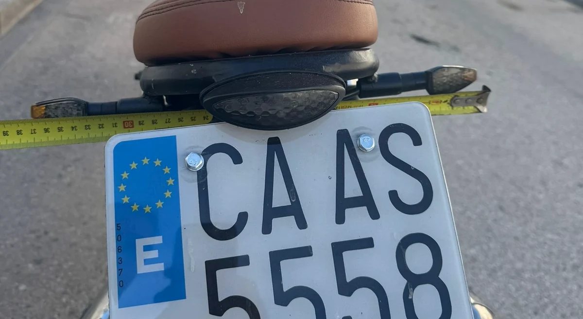 Midiendo con una cinta la separación entre los intermitentes traseros de una moto