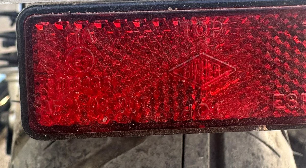 Marcado de homologación grabado en el catadióptrico trasero de una moto