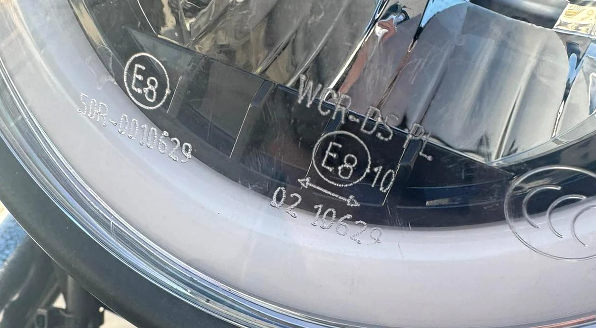 Marcado de homologación grabado en el cristal de un faro de moto