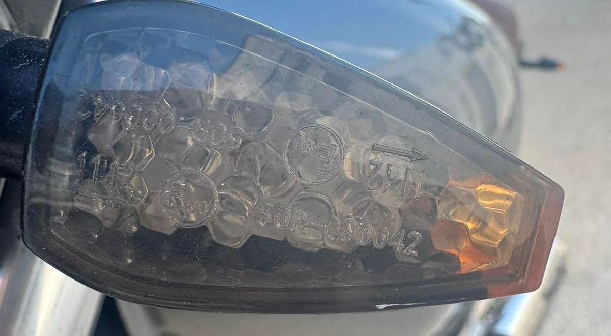 Marcado de homologación grabado en el cristal de un intermitente de moto